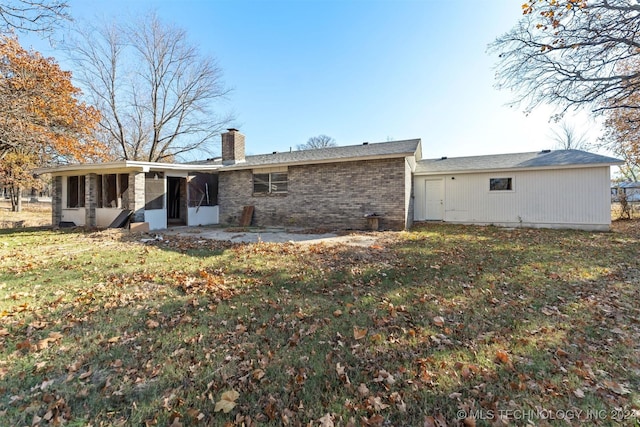 rear view of property with a sunroom and a lawn