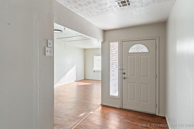 entrance foyer featuring wood-type flooring and a textured ceiling