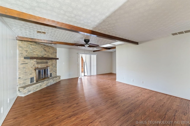 unfurnished living room featuring a brick fireplace, ceiling fan, a textured ceiling, and hardwood / wood-style flooring