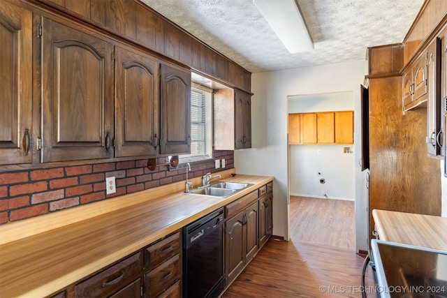 kitchen featuring dishwasher, a textured ceiling, dark hardwood / wood-style floors, and sink