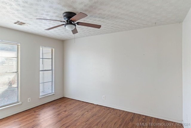 empty room featuring ceiling fan, hardwood / wood-style floors, and a textured ceiling