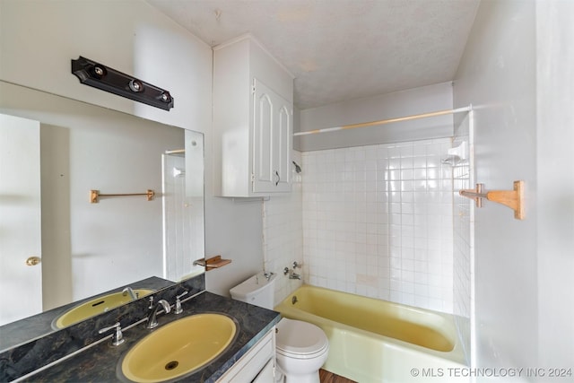 full bathroom with toilet, vanity, a textured ceiling, and tiled shower / bath