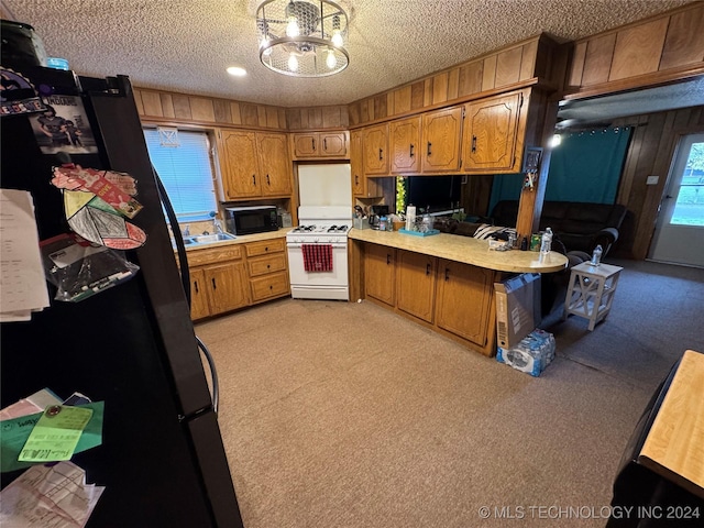 kitchen with black appliances, pendant lighting, a textured ceiling, and a chandelier