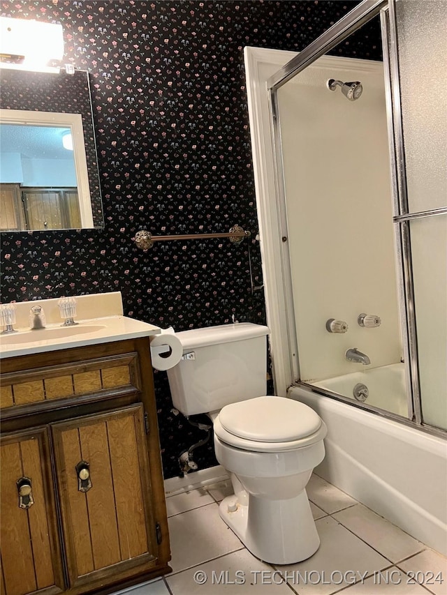 full bathroom featuring tile patterned floors, vanity, bath / shower combo with glass door, and toilet