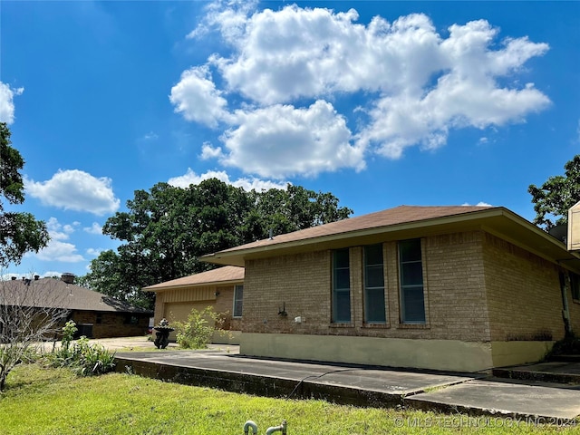 rear view of house with a yard and a garage