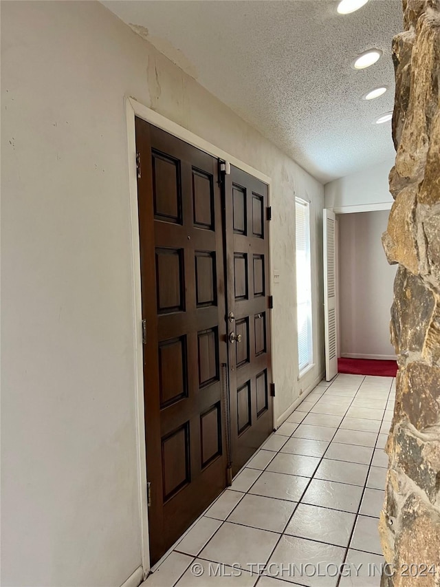 tiled entrance foyer featuring a textured ceiling