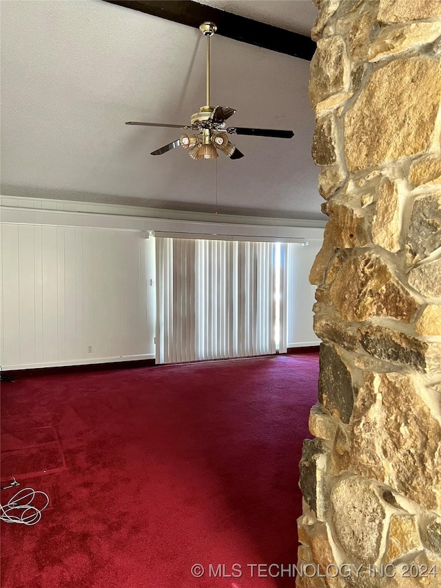 carpeted empty room with ceiling fan and lofted ceiling with beams