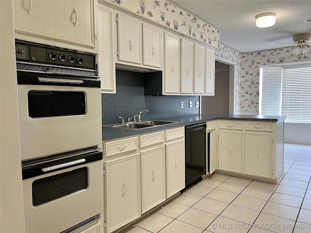 kitchen with dishwasher, double wall oven, sink, light tile patterned floors, and kitchen peninsula