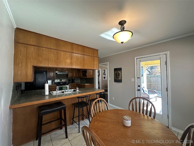 tiled dining space with sink and crown molding