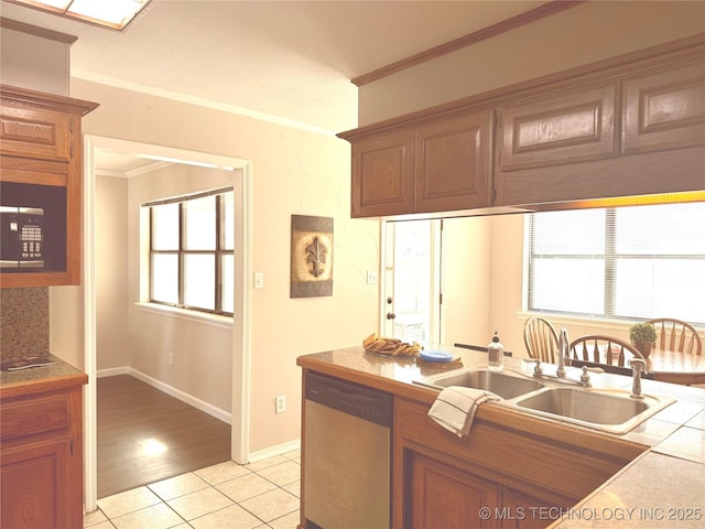 kitchen featuring dishwasher, tile counters, sink, light tile patterned floors, and crown molding