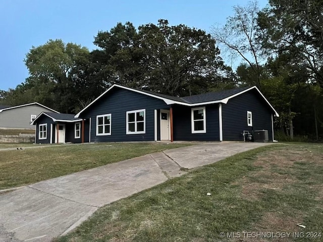 ranch-style house featuring central AC and a front lawn