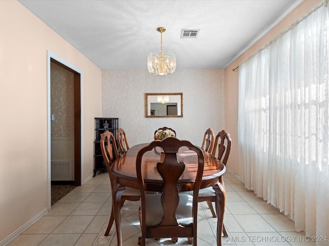 dining room with light tile patterned floors, a textured ceiling, and an inviting chandelier