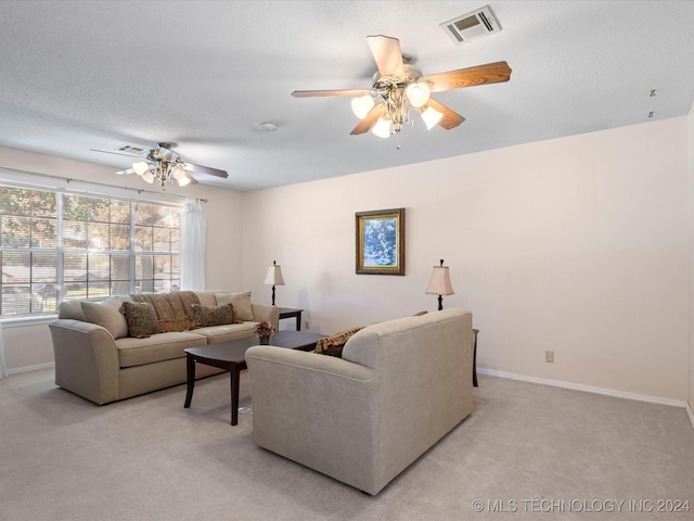 living room featuring a textured ceiling, ceiling fan, and light carpet