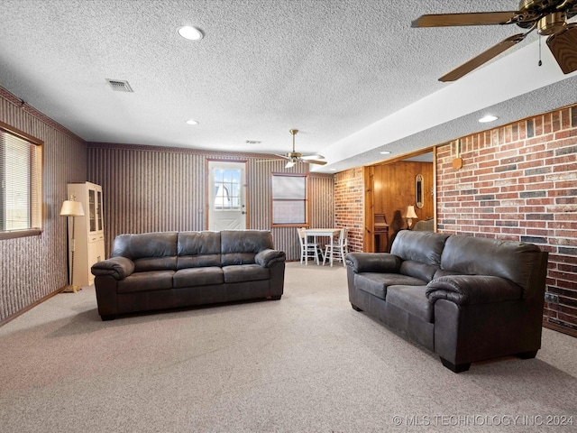 living room featuring light colored carpet, a textured ceiling, and wooden walls