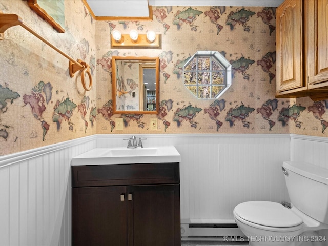 bathroom featuring vanity, wood walls, toilet, and a baseboard radiator