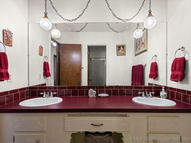 bathroom featuring decorative backsplash, an enclosed shower, and vanity