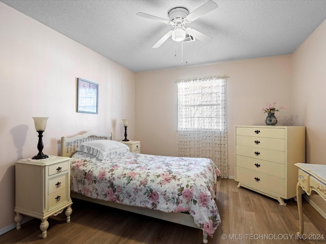 bedroom with hardwood / wood-style floors, ceiling fan, and a textured ceiling