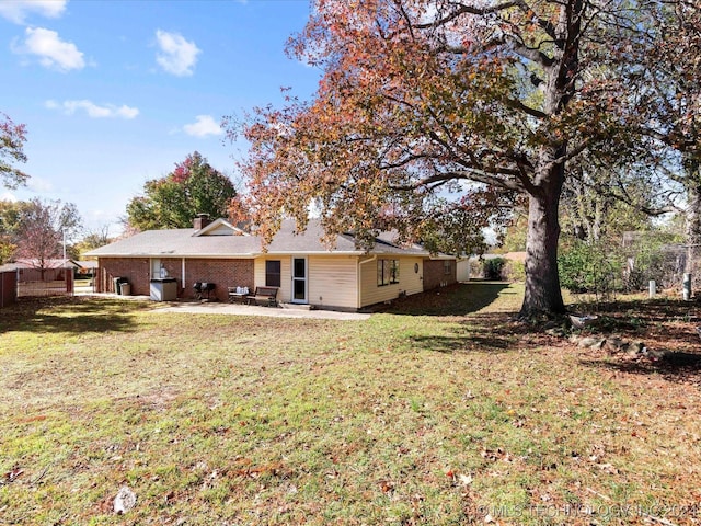 rear view of property featuring a yard and a patio