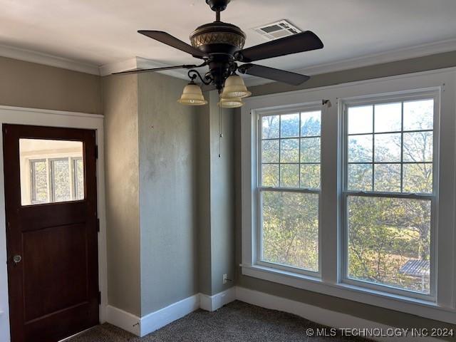 foyer with carpet flooring, ceiling fan, and ornamental molding