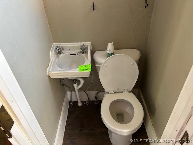 bathroom featuring hardwood / wood-style flooring, toilet, and sink