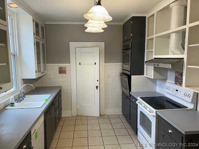 kitchen with white appliances, sink, decorative light fixtures, white cabinets, and light tile patterned flooring