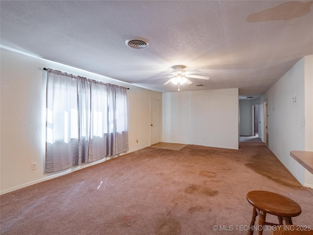 spare room with ceiling fan, carpet, and a textured ceiling