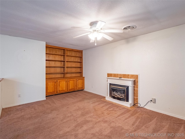 unfurnished living room with light carpet, built in shelves, a textured ceiling, and ceiling fan