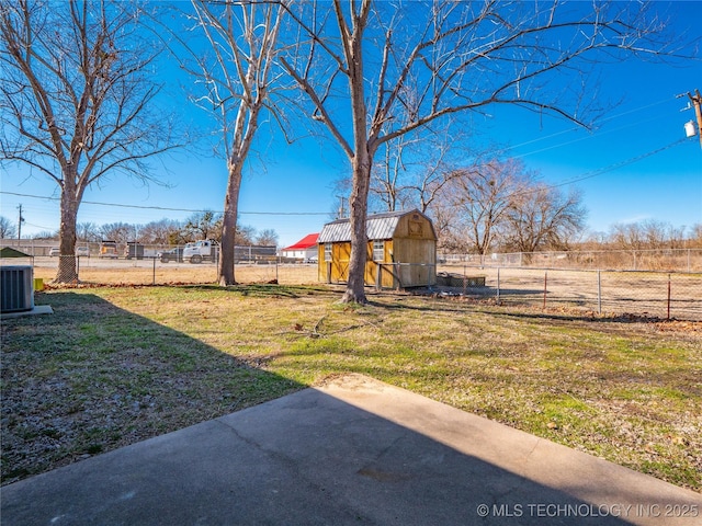 view of yard featuring central AC, a storage unit, and a patio