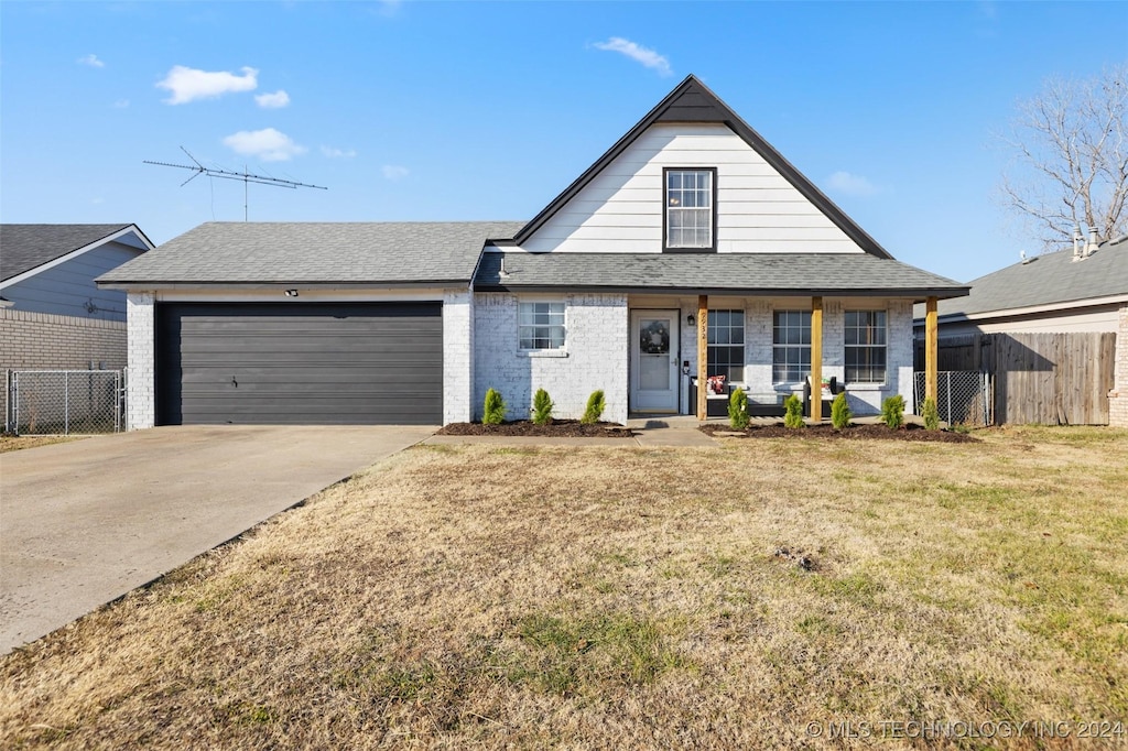 view of front of home featuring a garage, a front yard, and a porch