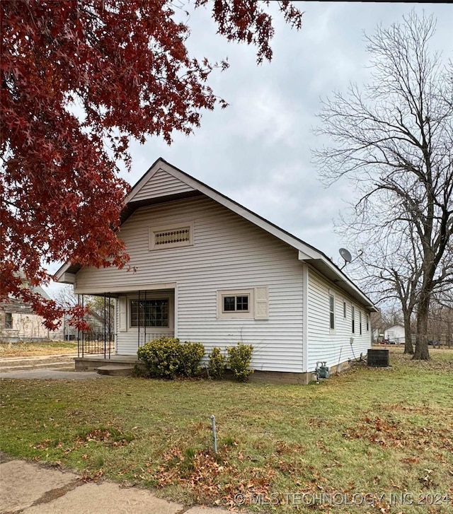 exterior space featuring a front yard, a porch, and cooling unit