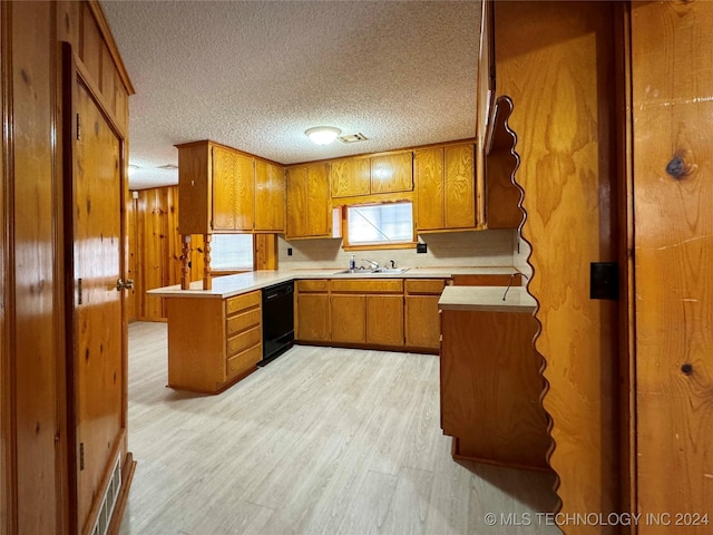 kitchen with kitchen peninsula, wooden walls, sink, dishwasher, and light hardwood / wood-style floors