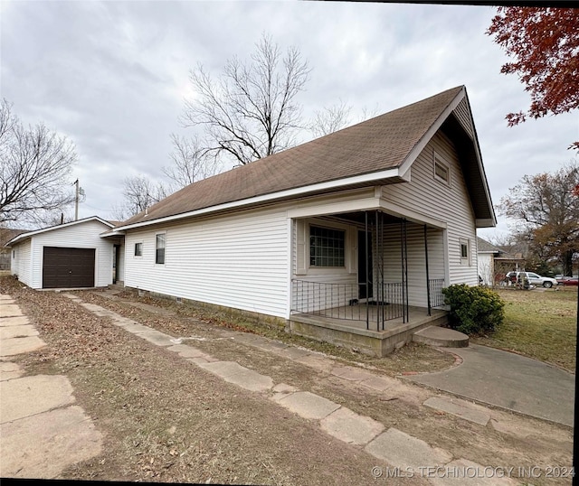 view of front facade featuring covered porch, an outdoor structure, and a garage