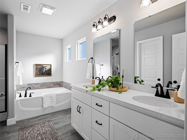 bathroom featuring shower with separate bathtub and vanity