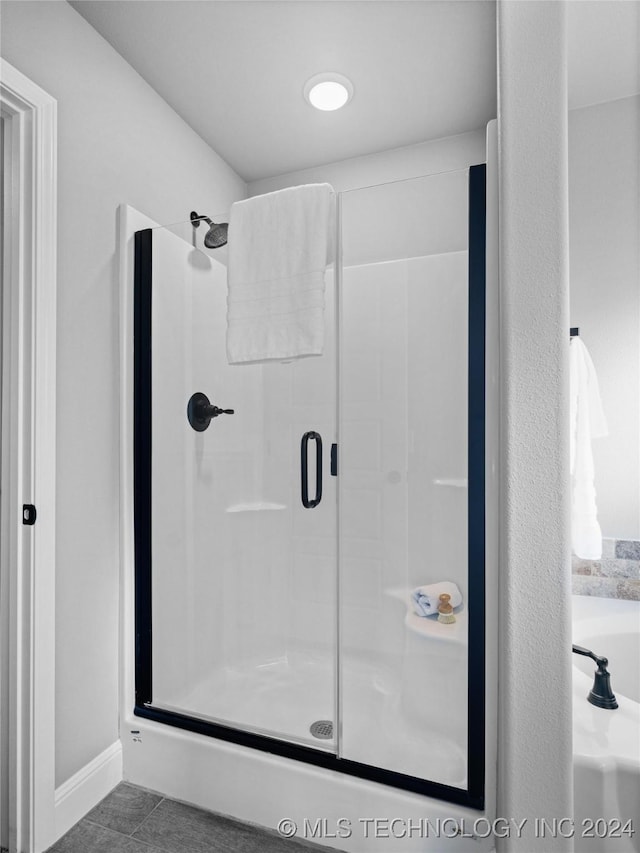 bathroom with tile patterned flooring and walk in shower