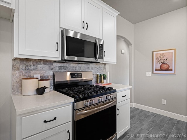 kitchen with white cabinets, backsplash, and appliances with stainless steel finishes