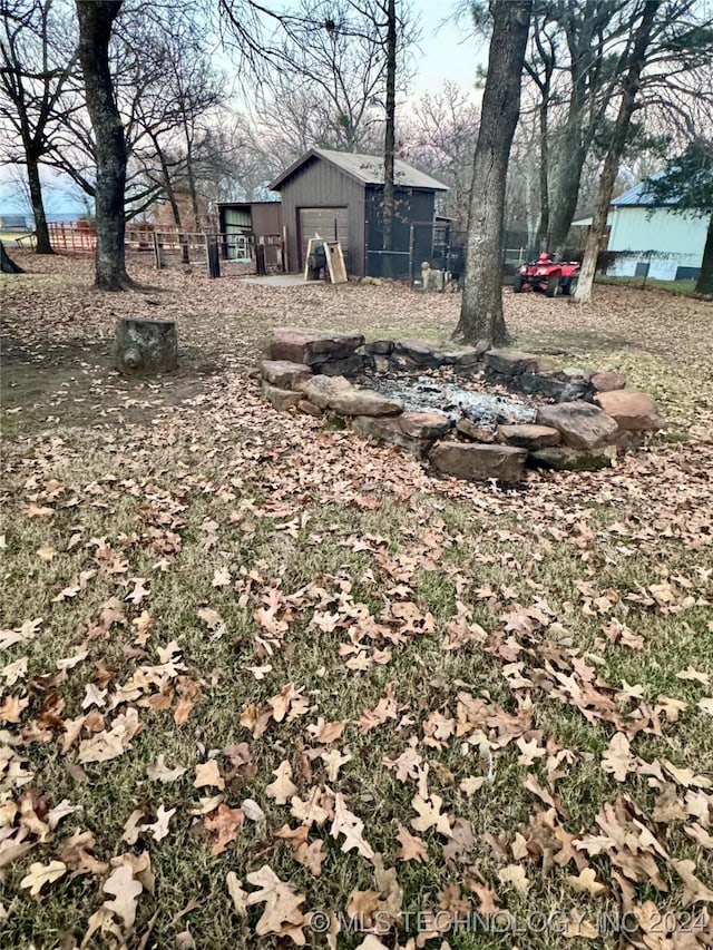 view of yard with a fire pit and an outdoor structure