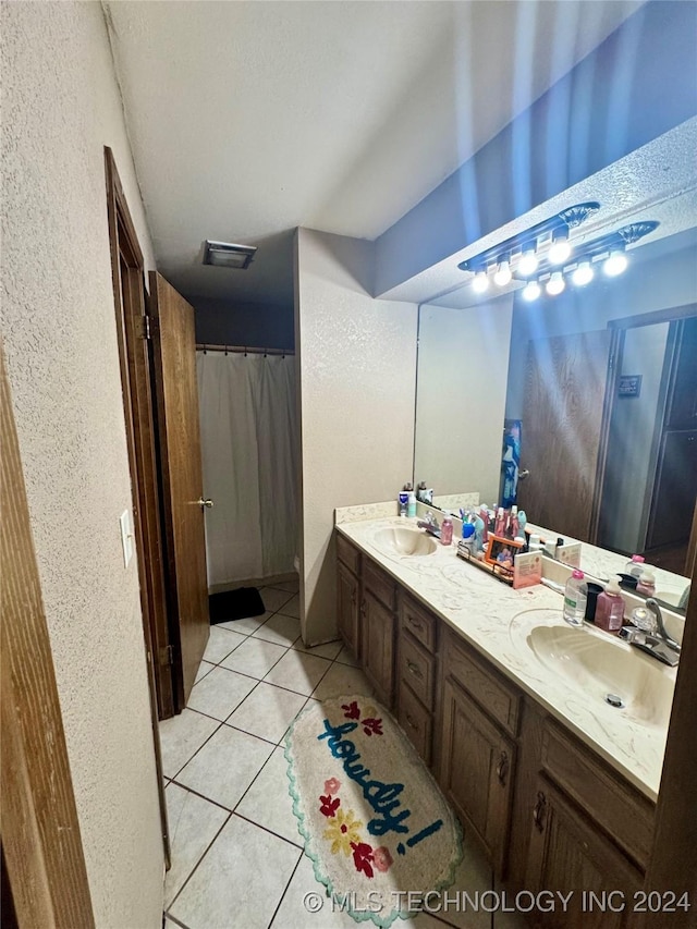 bathroom with curtained shower, tile patterned flooring, and vanity