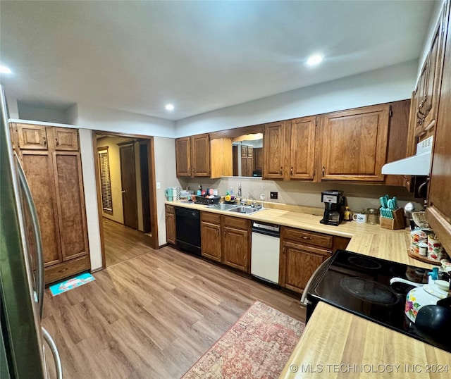 kitchen with light hardwood / wood-style floors, sink, black appliances, and ventilation hood