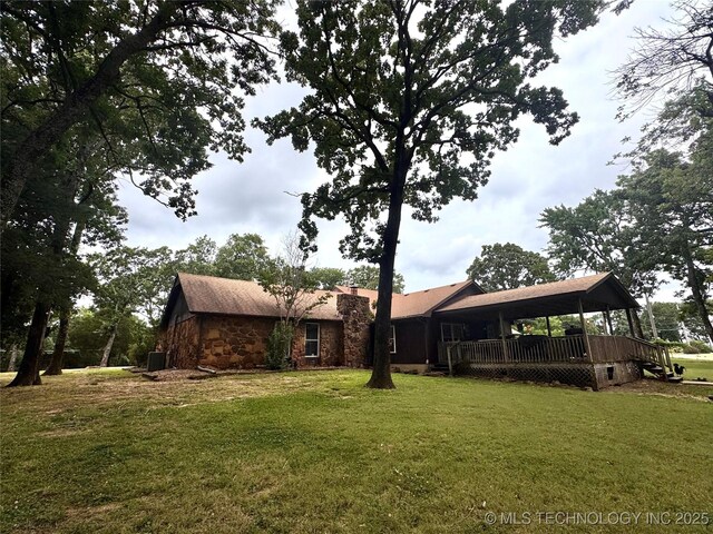 7750 River Ridge Rd, Muskogee, OK 74403 - view of front of house with stone siding, a front lawn, a chimney, and a deck