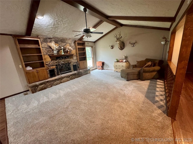 7750 River Ridge Rd, Muskogee, OK 74403 - living area with a ceiling fan, a stone fireplace, carpet floors, a textured ceiling, and built in shelves