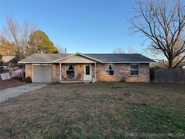 single story home featuring driveway, brick siding, an attached garage, and fence