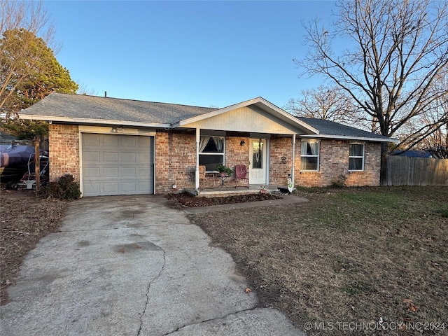 ranch-style home with an attached garage, fence, concrete driveway, and brick siding