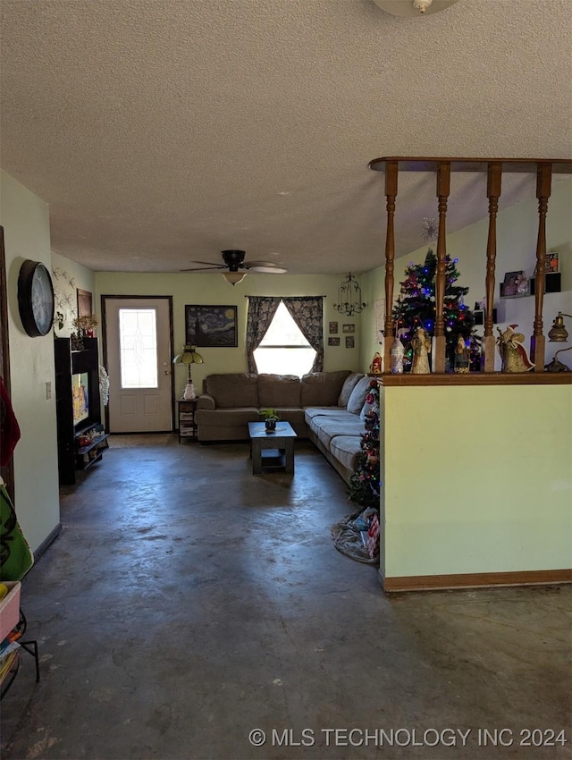 unfurnished living room featuring unfinished concrete flooring, a textured ceiling, and ceiling fan