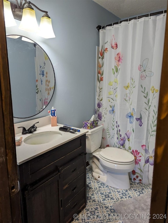 bathroom featuring toilet, vanity, a textured ceiling, a shower with curtain, and tile patterned floors