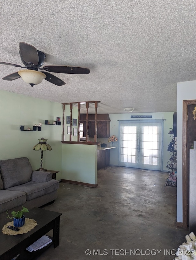 living area featuring ceiling fan, a textured ceiling, and concrete flooring