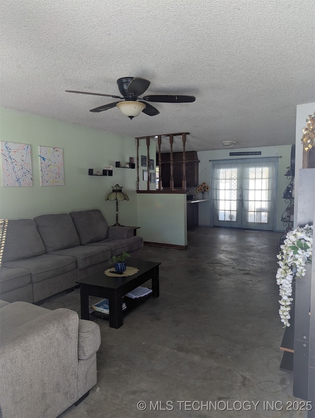 living room featuring a textured ceiling, ceiling fan, and concrete floors