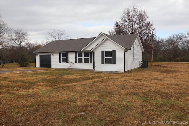 ranch-style home with a garage, a front yard, and central AC