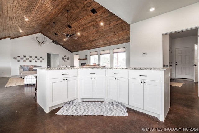 kitchen with white cabinets, light stone countertops, and wood ceiling