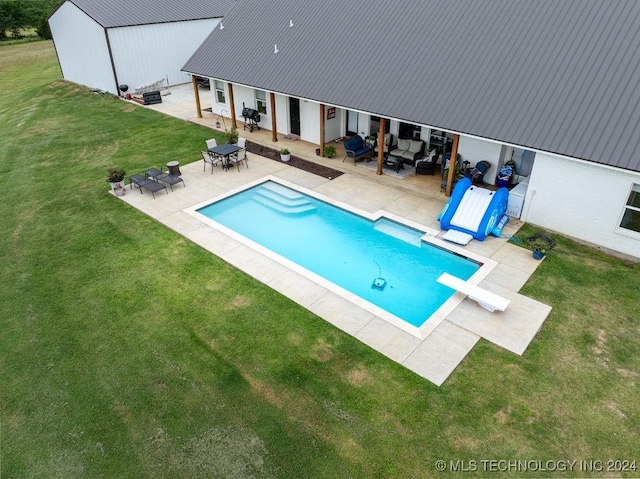 view of swimming pool with an outdoor living space, a diving board, a patio area, and a yard