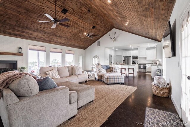 living room with ceiling fan, wood ceiling, high vaulted ceiling, and a brick fireplace